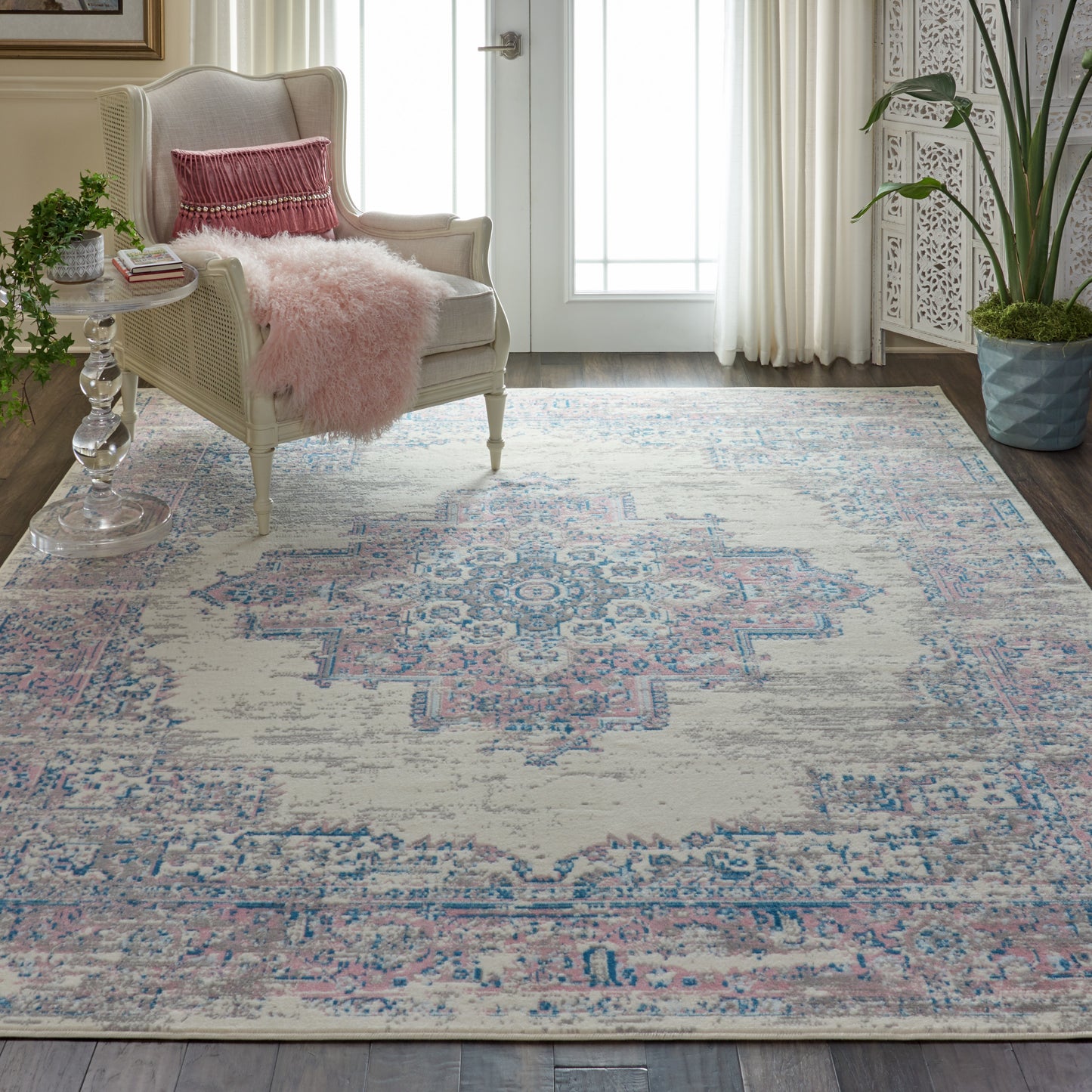 Pastel pink-blue distressed oriental rug (9' x 12') in a bright living room.