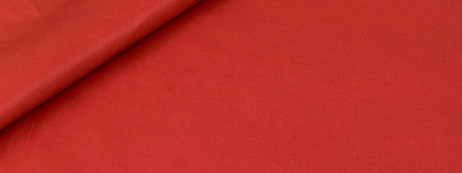 Bright red fabric with a diagonal fold, smooth matte texture & soft drape.
