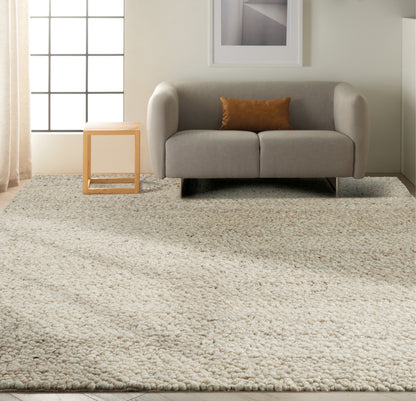 Grey contemporary rug with a chunky ivory shag texture in a living room, natural wood side table, grid window & art.