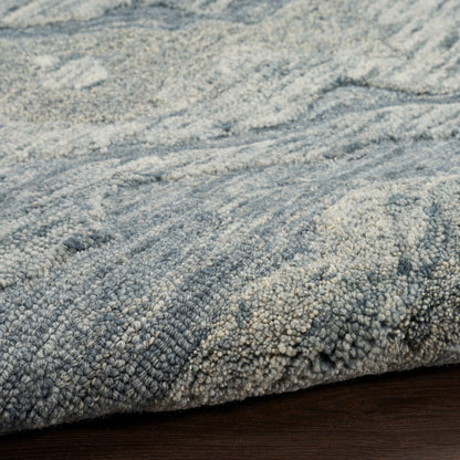 Close-up of a blue-gray area rug with dense loop-pile texture on a dark wood floor