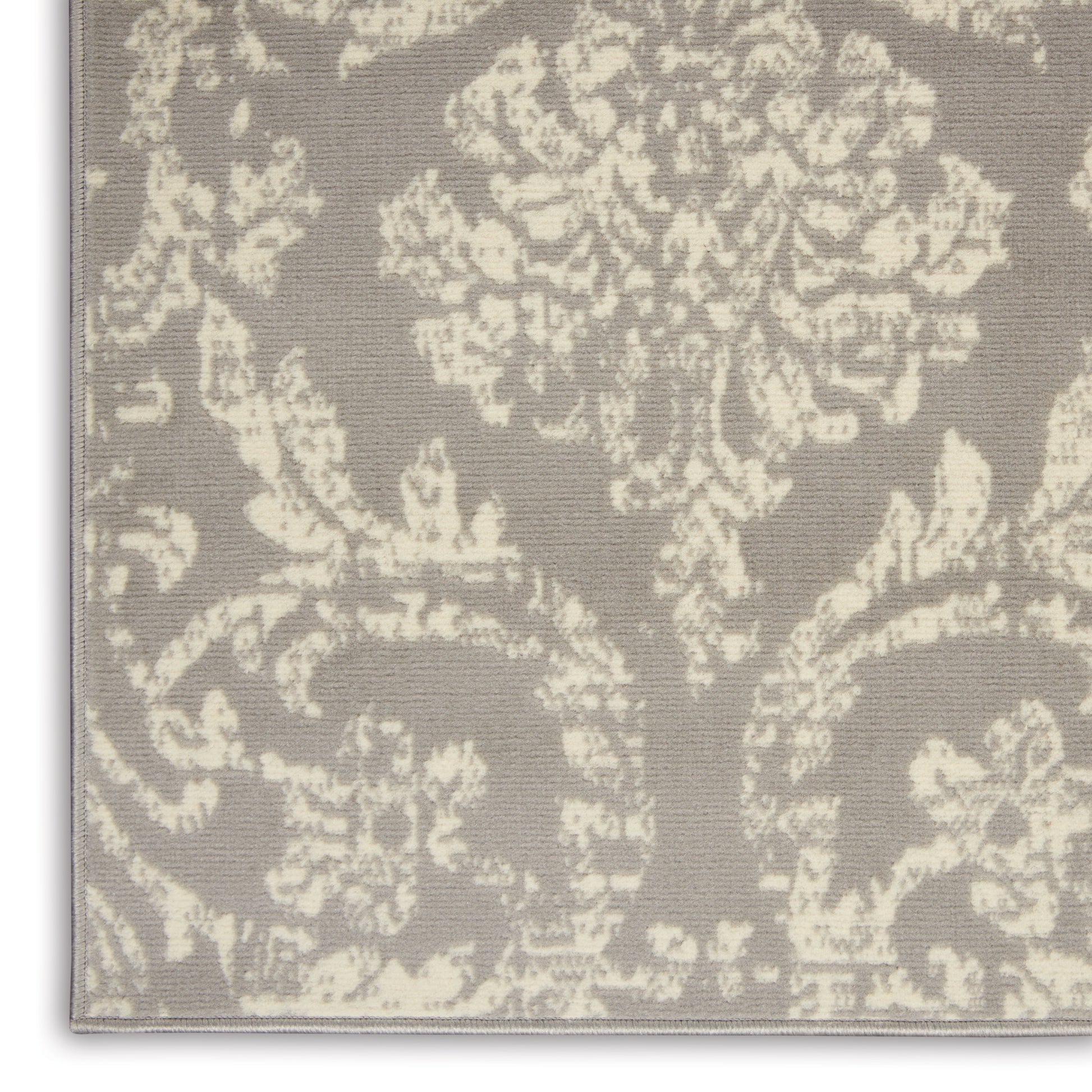 Taupe rug with ivory damask floral pattern and woven texture.