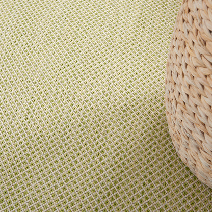 Natural wicker basket beside lime-green grid-pattern fabric, rustic coastal home decor.
