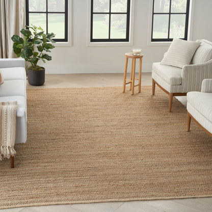 Neutral living room with a large natural jute rug, cream sofas, light wood legs, potted plant, and small wooden side table.