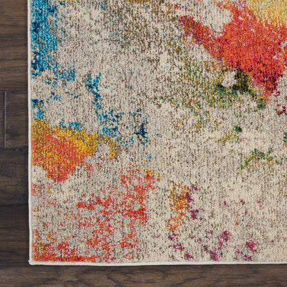 Shaggy abstract area rug with a beige base and bright blue, pink, yellow and green splashes on a dark wood floor.