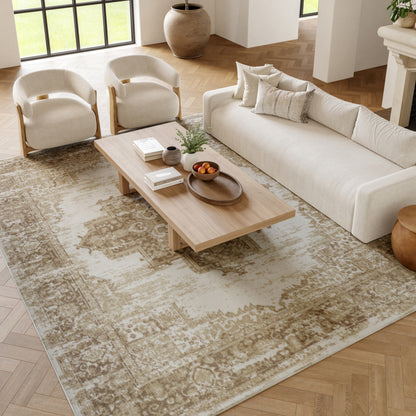 Neutral living room with beige fabric sofa, two cream rounded armchairs, light wood coffee table, and a beige patterned rug.