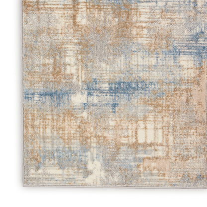 Abstract beige, tan & blue area rug with a soft textured pile & muted distressed pattern.