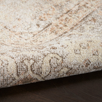 Beige patterned area rug with plush pile and swirling motif, rolled edge on dark wooden floor