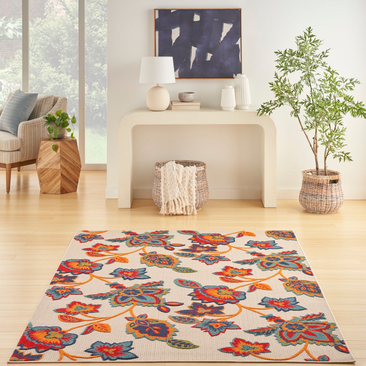 Woven area rug with vibrant blue, red and yellow floral pattern on cream background in a bright living room.