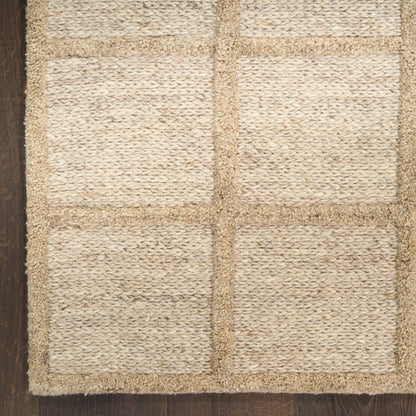 Natural jute rug with beige square grid panels and rustic woven texture on dark wood floor.