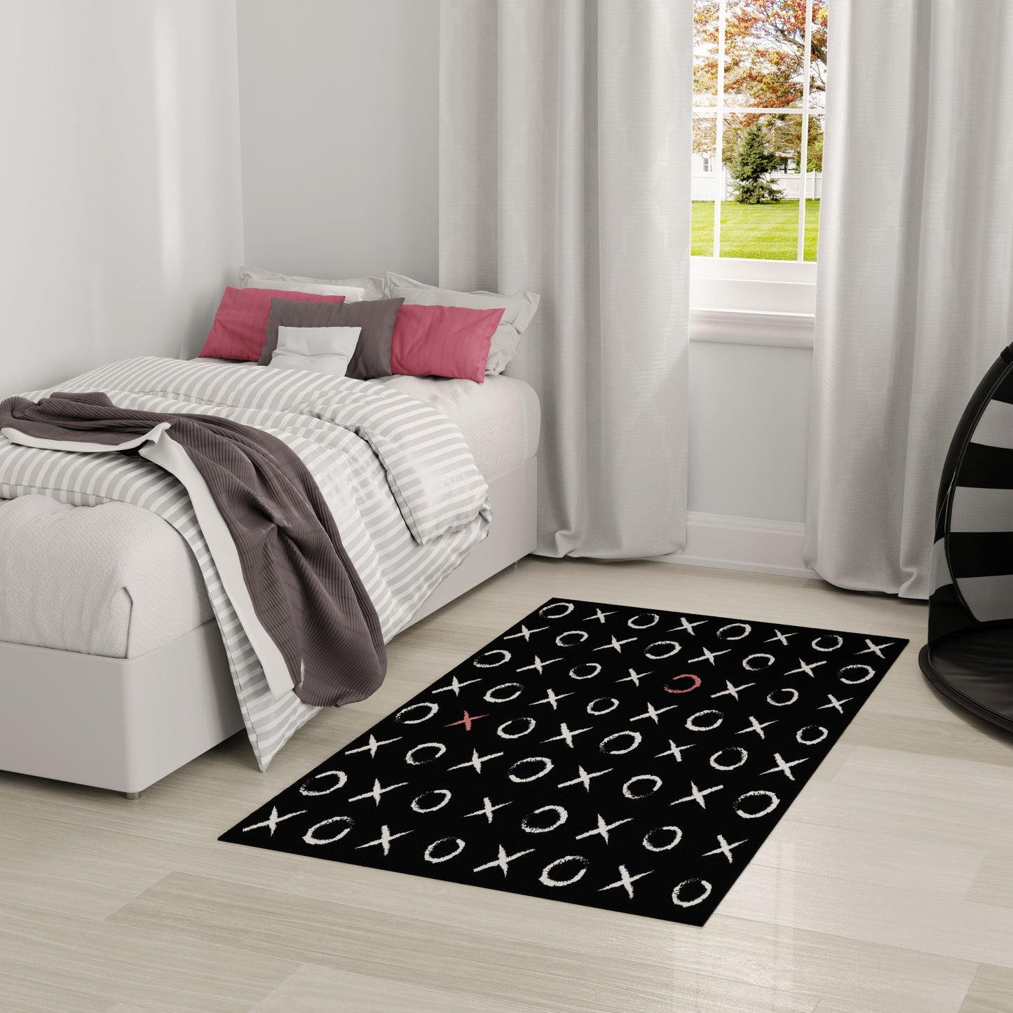 Modern bedroom with white platform bed, striped gray duvet, pink and gray pillows, black tic-tac-toe rug, light wood floor.