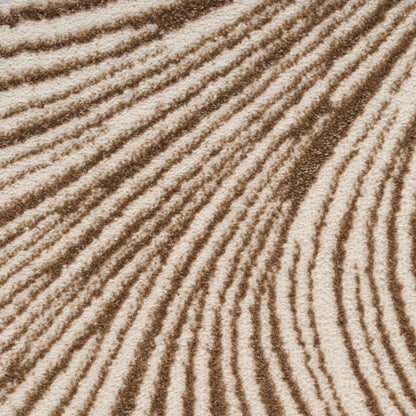 Close-up of beige-brown rug texture with a sand-textured surface and repeating wavy ridges.