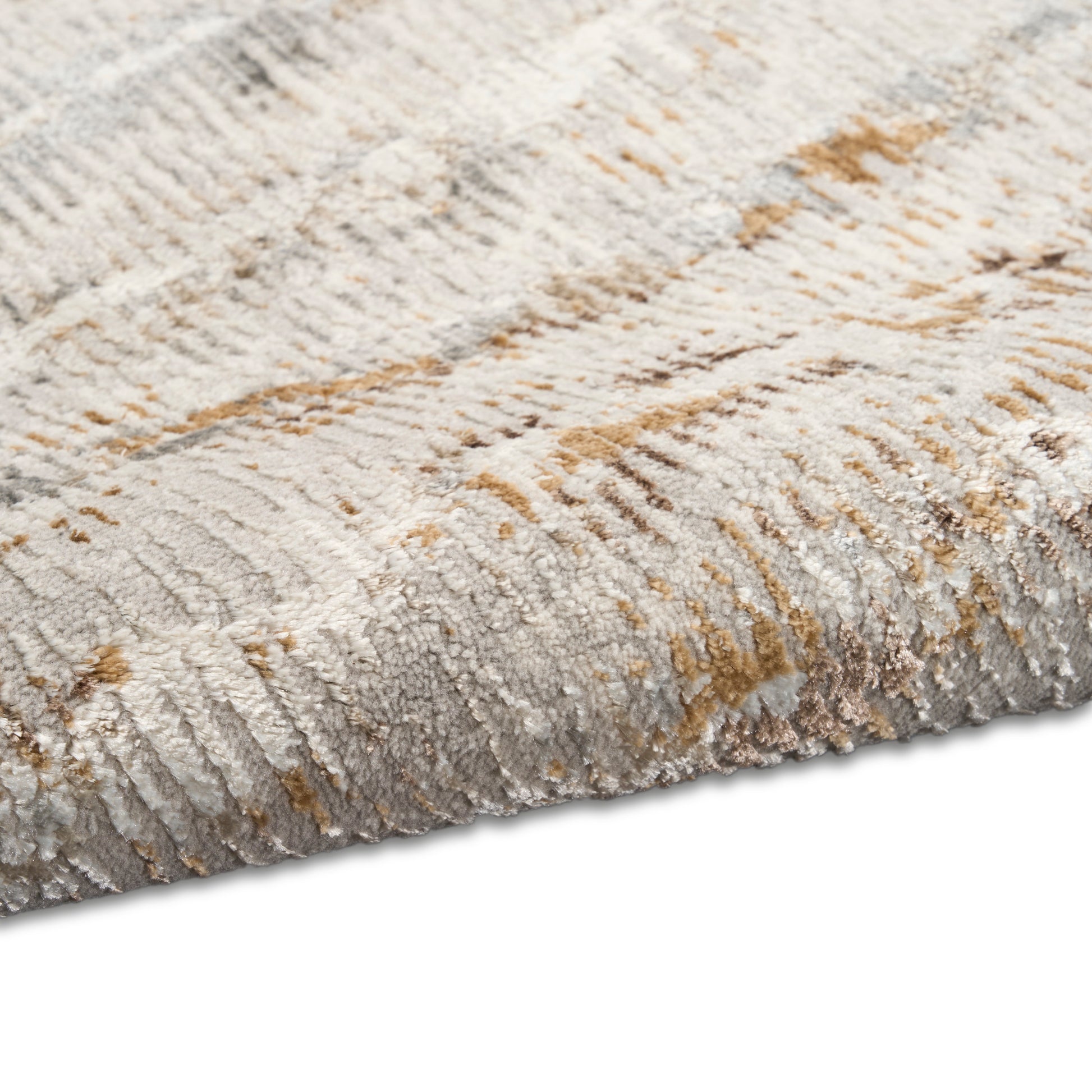 Close-up of a plush, neutral-toned rug with ivory, gray and tan hues and a folded edge.