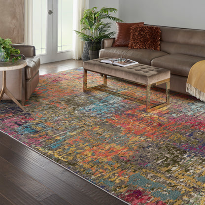 Colorful abstract area rug in a modern living room with a brown leather sofa, tufted ottoman, gold legs, and potted plants.