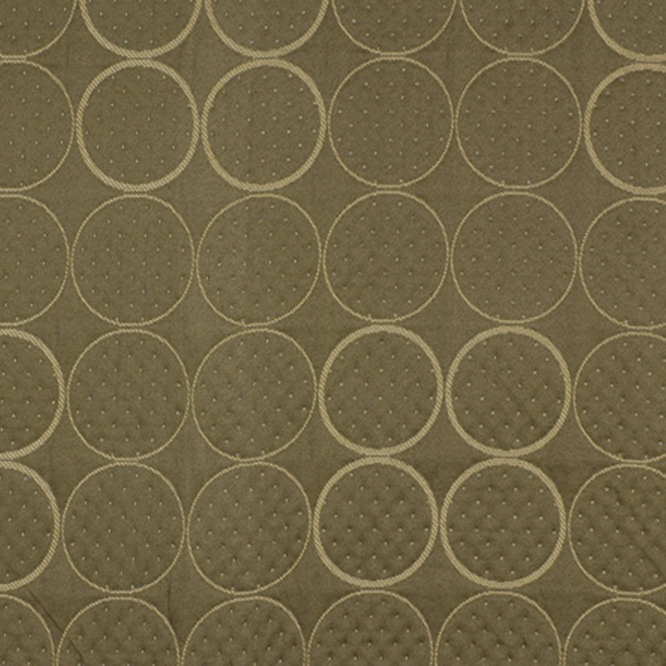 Olive-brown quilted fabric with repeating circle patterns and dotted centers, ideal upholstery or cushion fabric.