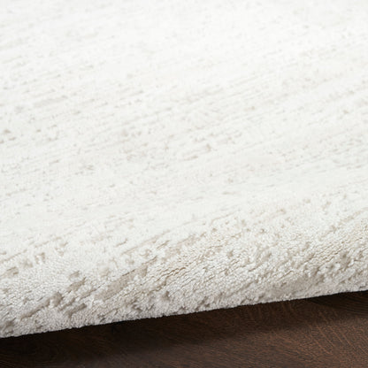 Cream plush rug with subtle textured pattern and soft pile on dark wood floor.