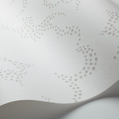White textured material with delicate gray dotted lace pattern and a curved fold.