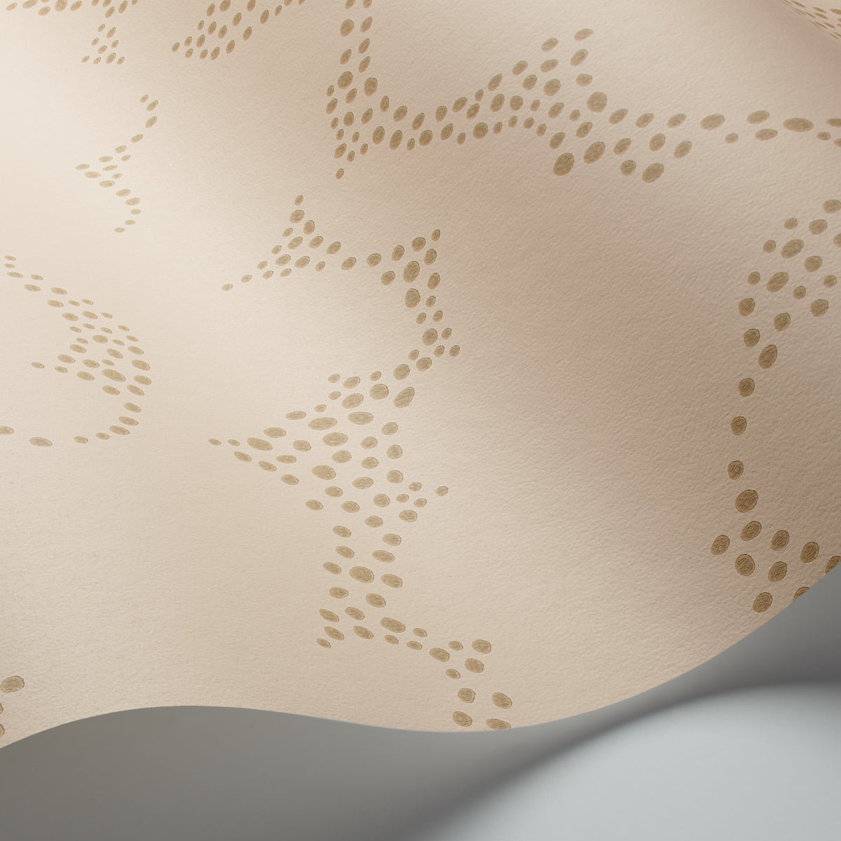 Beige fabric with tan dotted embroidery creating abstract, wavy patterns; soft textile texture.