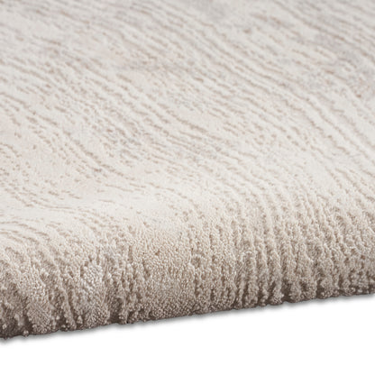 Beige plush rug with soft loop-pile and subtle wave texture, close-up edge.