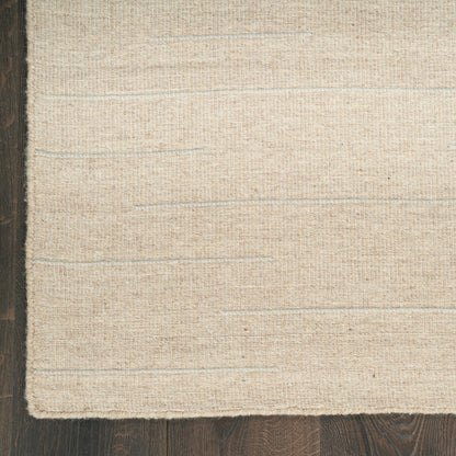 Beige flatwoven rug with subtle horizontal stripes on a dark wood floor.