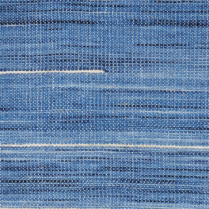 Blue woven rug with irregular lighter-blue stripes and subtle white specks; textured denim-like textile.