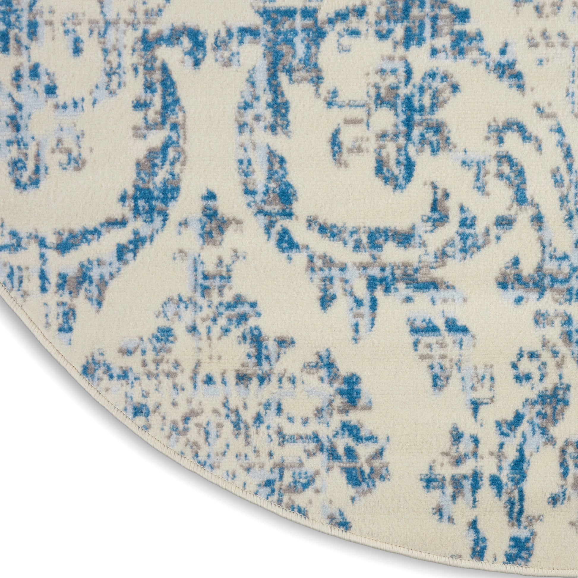 Round cream rug with blue distressed oriental medallion pattern and soft woven texture.