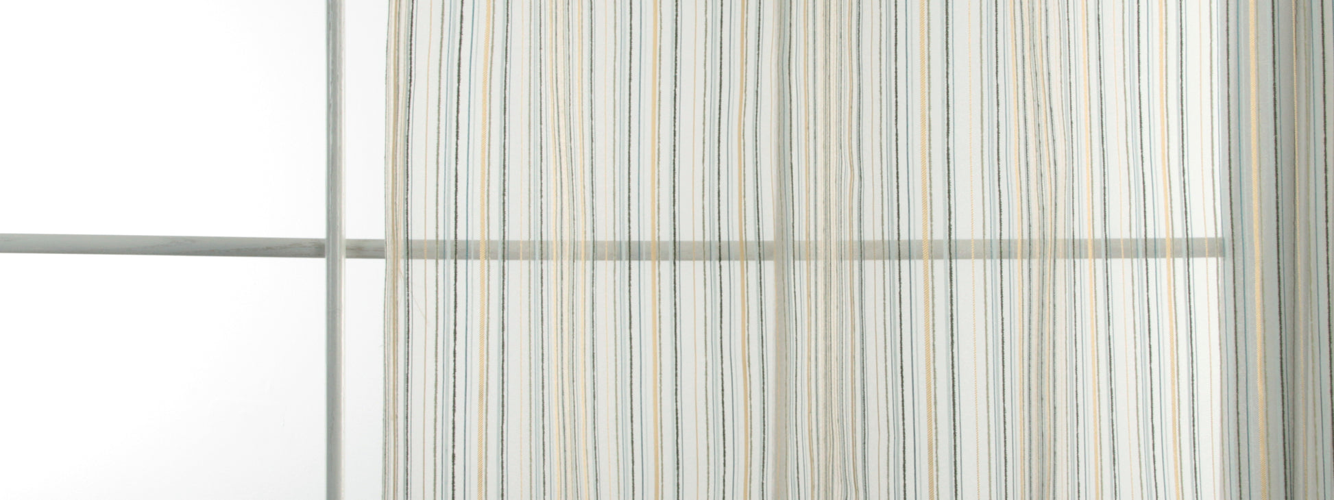Striped sheer curtain in pale blue, beige, and white hanging from a metal rod beside a window.