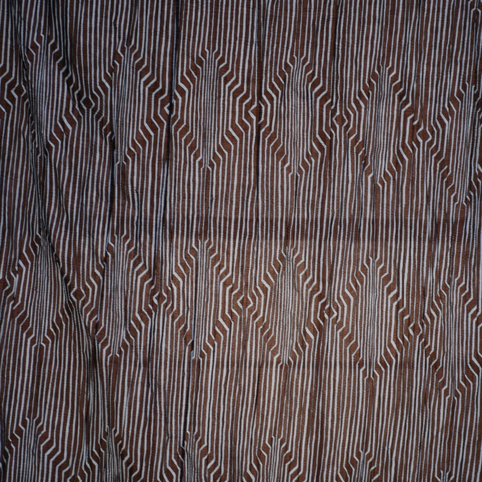Dark blue woven fabric with white zigzag geometric stripes, lightweight drapery fabric.