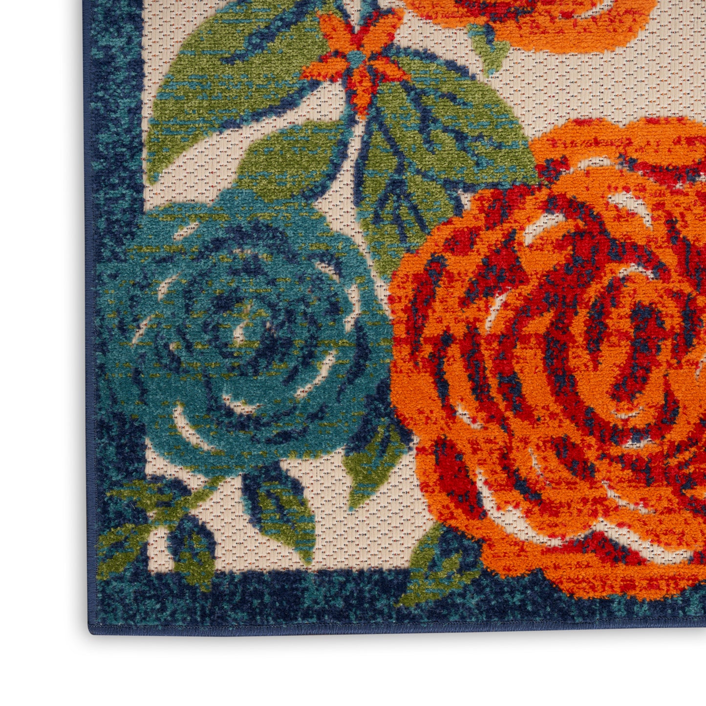 Close-up of a woven floral rug with orange and teal roses and a dark teal border.