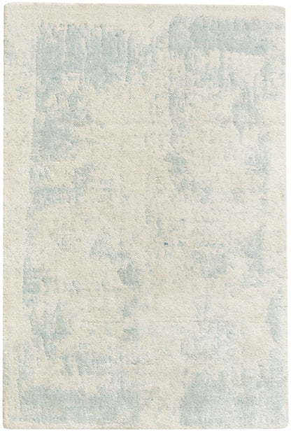 Rectangular area rug in cream with a pale blue abstract pattern and plush, soft pile.