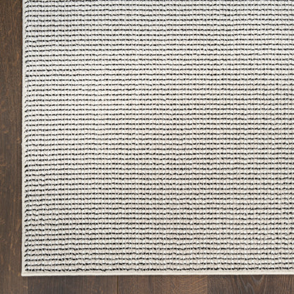 Beige woven area rug with thin black horizontal stripes on a dark wood floor.