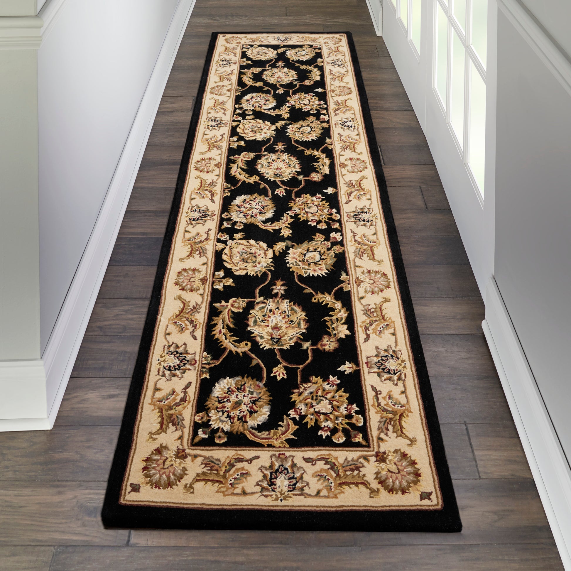 Persian-style long runner rug: black field with beige-gold floral motifs, cream-gold border; hallway decor.