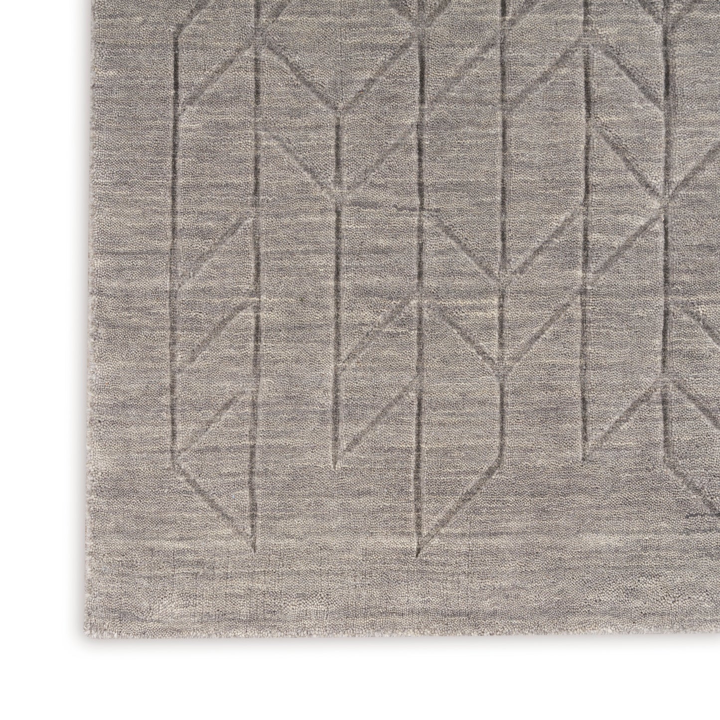 Taupe area rug with a subtle geometric diamond/chevron motif along the edge; soft woven texture.