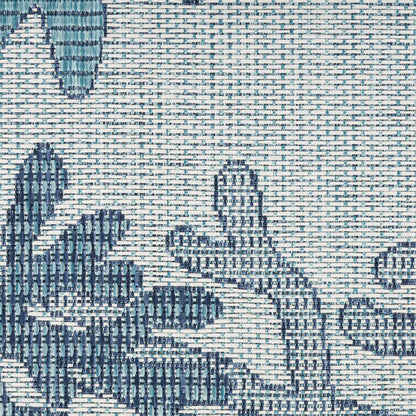 Close-up of blue and teal leaf pattern on a textured woven fabric, suitable for upholstery or decor.