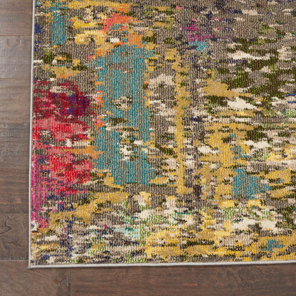 Rectangular colorful abstract woven area rug with teal, yellow, pink, red and olive tones on a wooden floor.