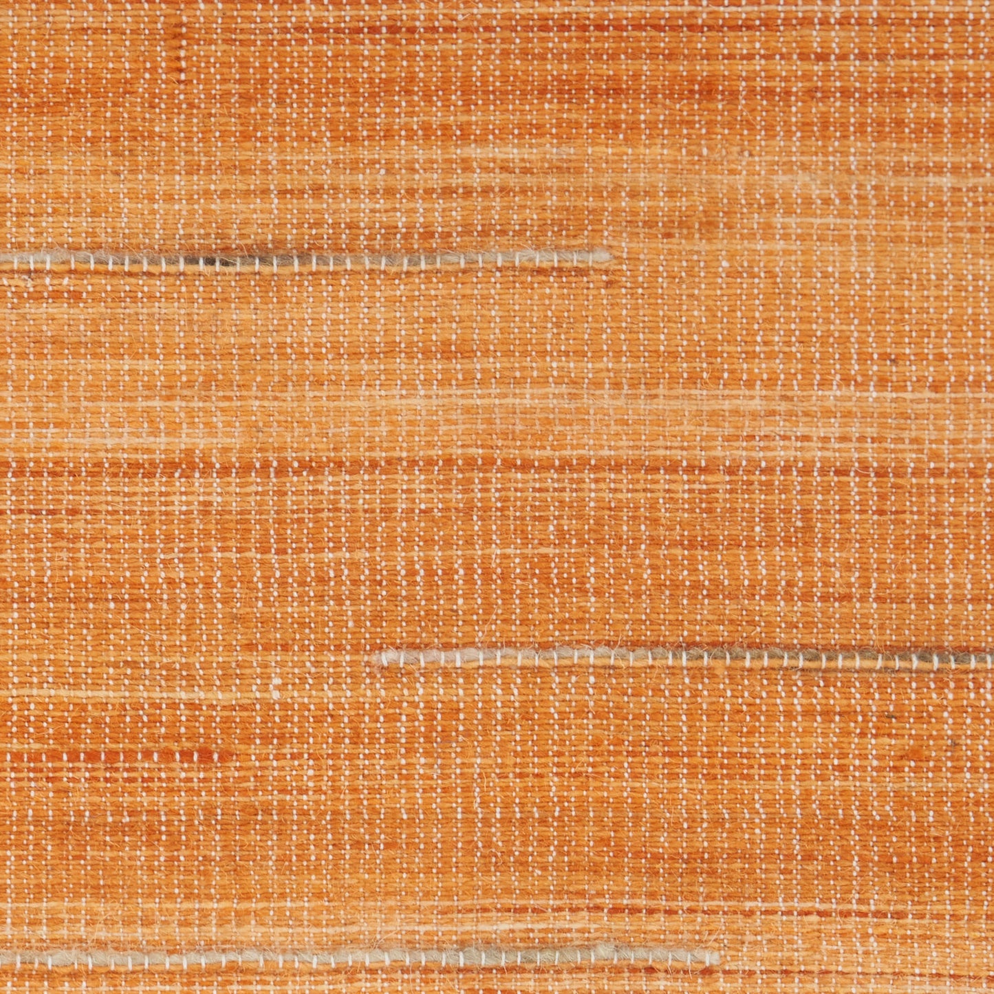 Orange woven rug with white specks and subtle horizontal stripes; rustic linen-like texture.