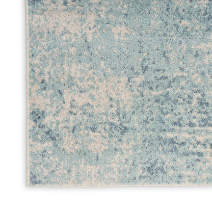 Blue and cream distressed abstract rug with mottled pattern and soft texture.