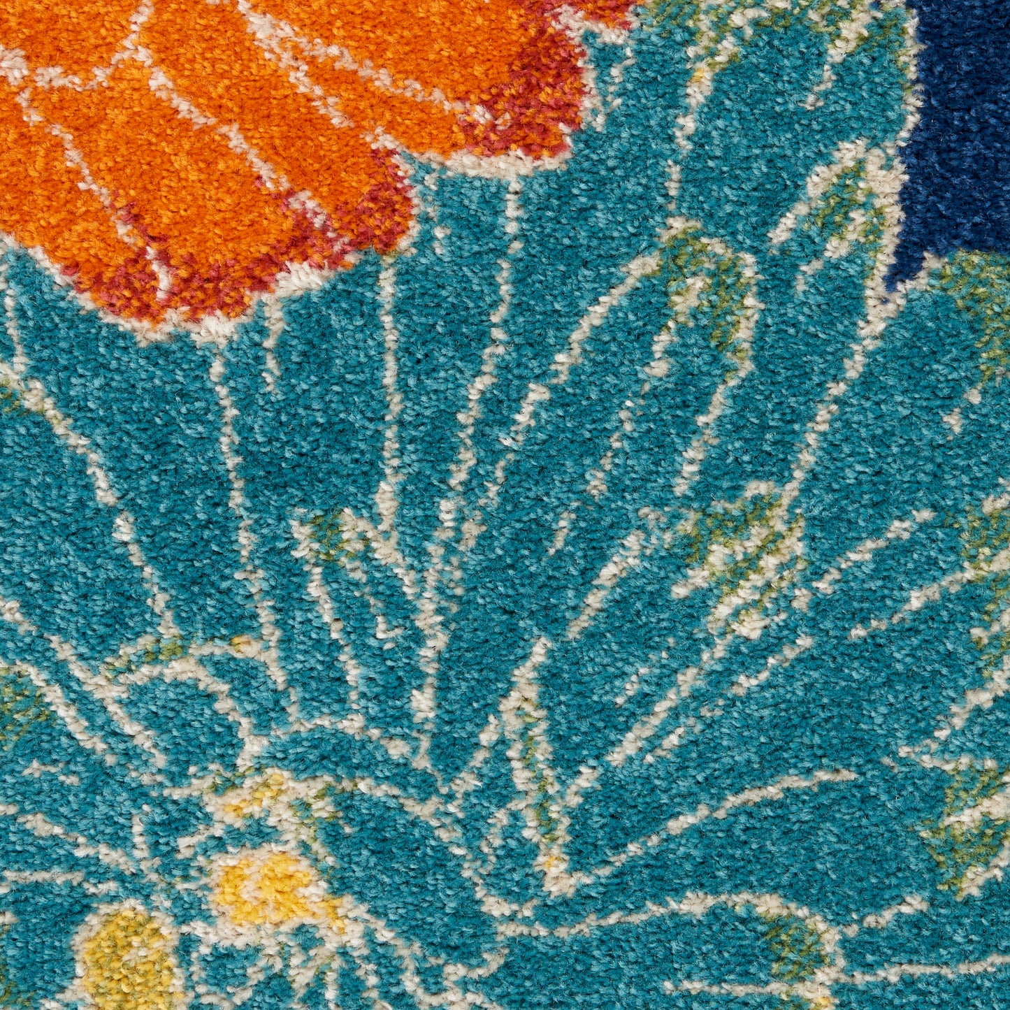 Shaggy turquoise rug with white radiating lines, orange floral motif & yellow accents; soft decorative area rug.