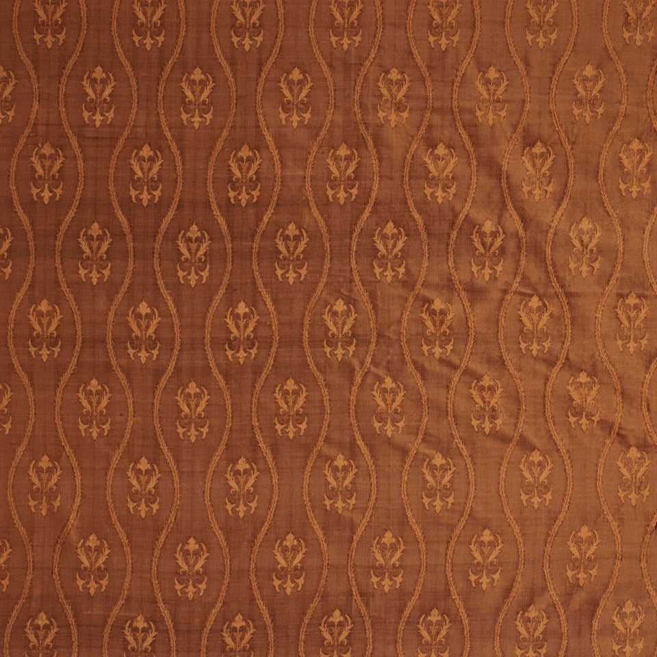Rust-brown jacquard fabric with vertical wavy lattice & gold floral motifs; damask-style textile.