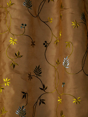 Brown satin drapery fabric with embroidered vines and leaves in yellow, black and light blue, decorative botanical pattern.