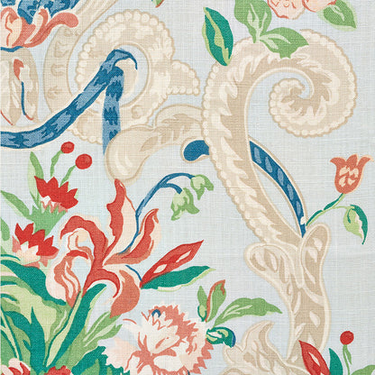 Floral damask textile with beige scrolls, blue ribbons, red flowers and green leaves on pale background.
