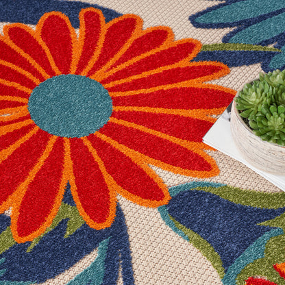 Vibrant floral rug with a large orange-red daisy, turquoise center, beige woven backdrop; small succulent on a book.