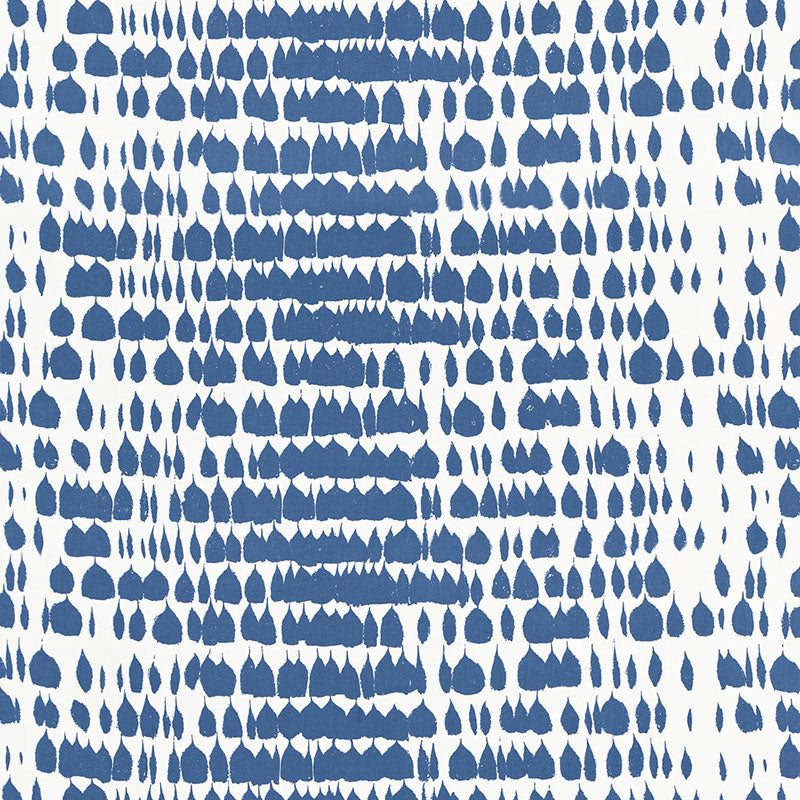Blue teardrop-shaped prints arranged in a geometric ikat-like pattern on white fabric; bold, contemporary textile design.