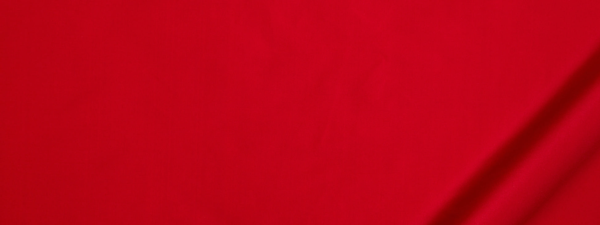Bright red fabric with subtle diagonal lines and right-edge shadows, smooth and bold.