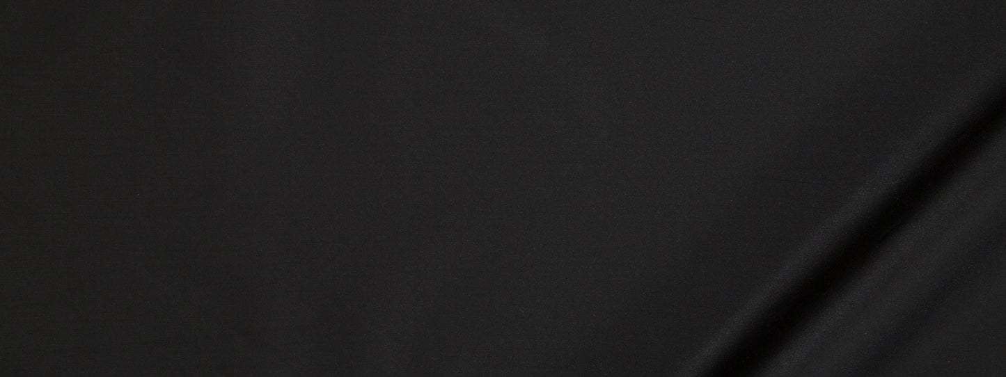 Close-up of dark black fabric with a subtle diagonal crease and smooth matte finish.