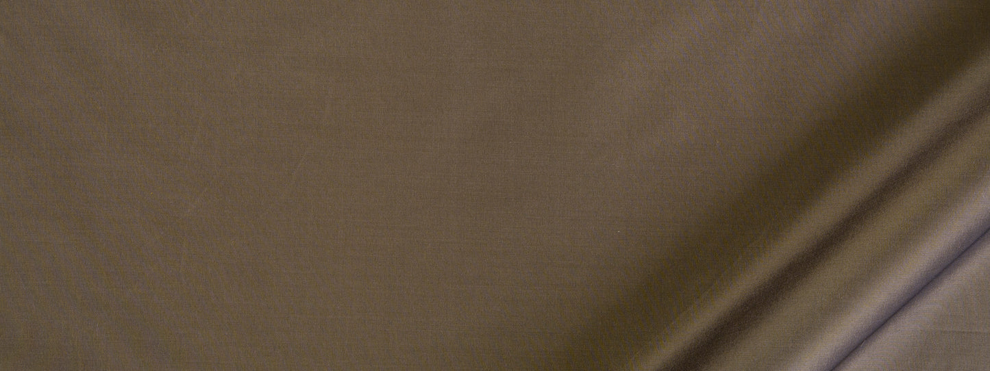 Close-up of tan-brown fabric with visible weave and diagonal crease, textured textile