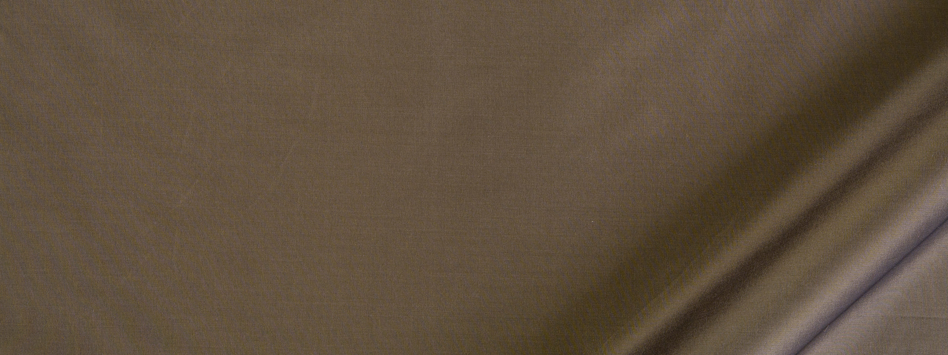 Close-up of tan-brown fabric with visible weave and diagonal crease, textured textile
