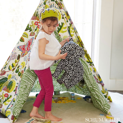 Colorful fabric with leafy and butterfly print; child in white top and magenta pants holds a black-and-white geometric bag.