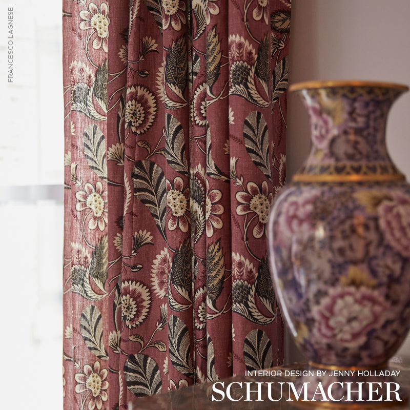 Rich burgundy floral curtain fabric with cream flowers and green leaves beside a purple and gold ceramic vase.