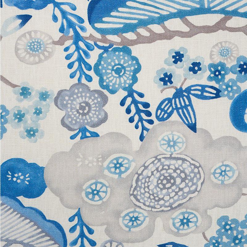 Beige linen-like fabric with blue botanical print: large gray-blue flowers, small blue blossoms, and leafy swirls.