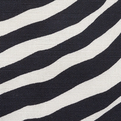 Close-up of zebra-striped black & white woven fabric showing bold pattern and textured surface.